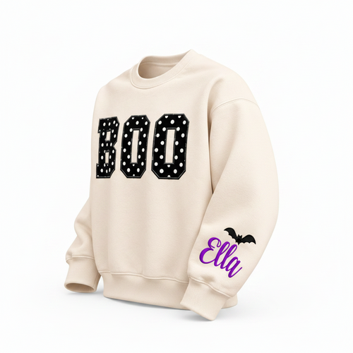 Label Stitch Studio cream fleece crewneck sweatshirt with black polka-dot BOO letters and personalized sleeve name.