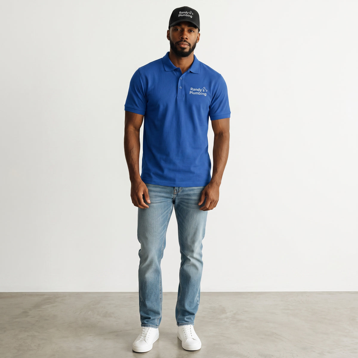Label Stitch Studio custom embroidered black baseball cap worn by a man in a blue polo shirt and light wash jeans